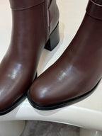 Brown leather heeled ankle boot close-up of toe and side seam