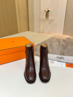 Pair of brown leather heeled ankle boots with gold logo buckle