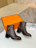 Brown leather heeled ankle boots with gold logo buckle, side-by-side