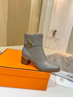 Light gray leather ankle boots with gold buckle at side and stacked wooden heel