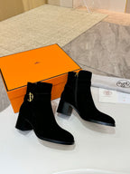 Black suede ankle boots with gold logo on side and squared block heel