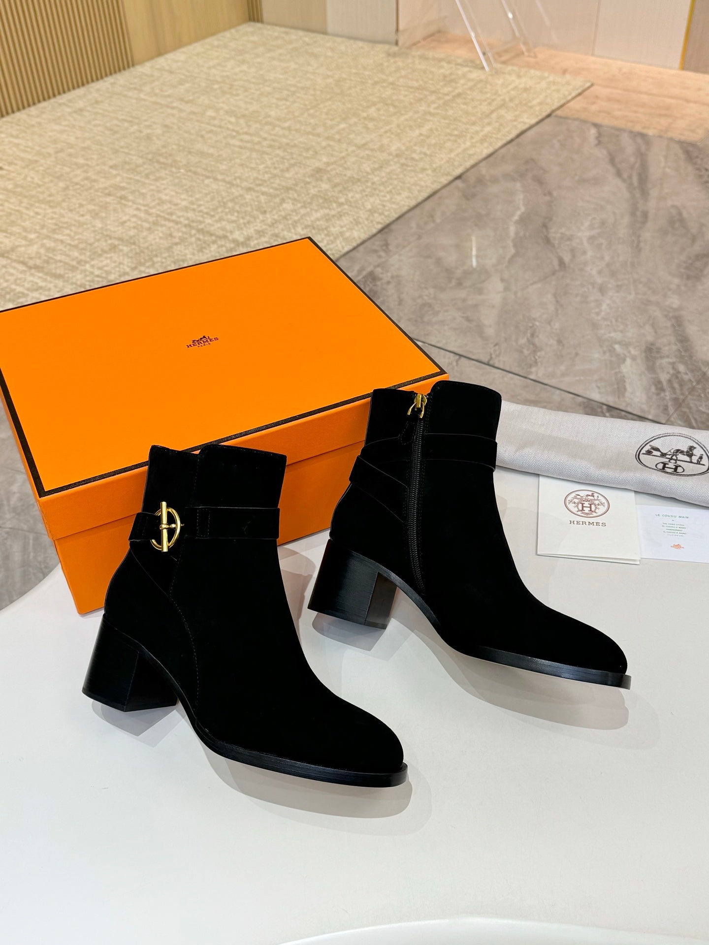 Black suede ankle boots with gold logo on side and squared block heel