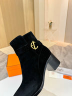 Black suede ankle boot with gold logo strap and square block heel