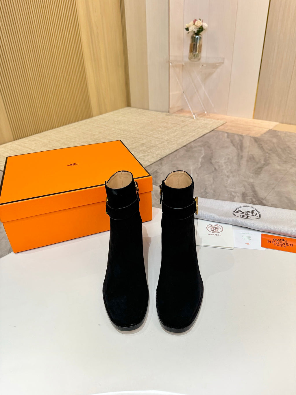 Pair of black suede ankle boots with gold logo accents and block heels