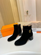 Two black suede ankle boots with gold logo buckle and mid block heel