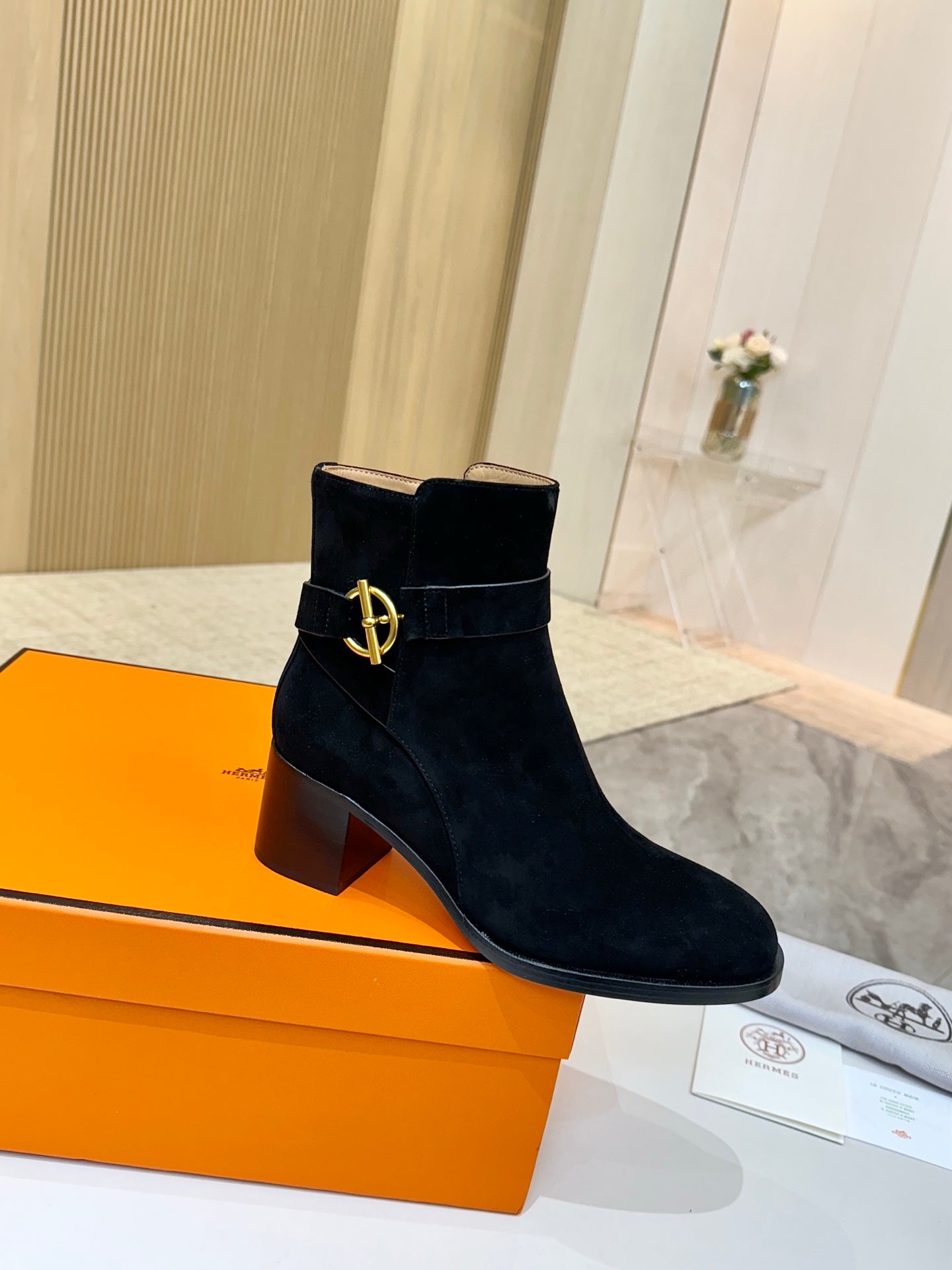 Black suede ankle boots with gold logo buckle and block heel