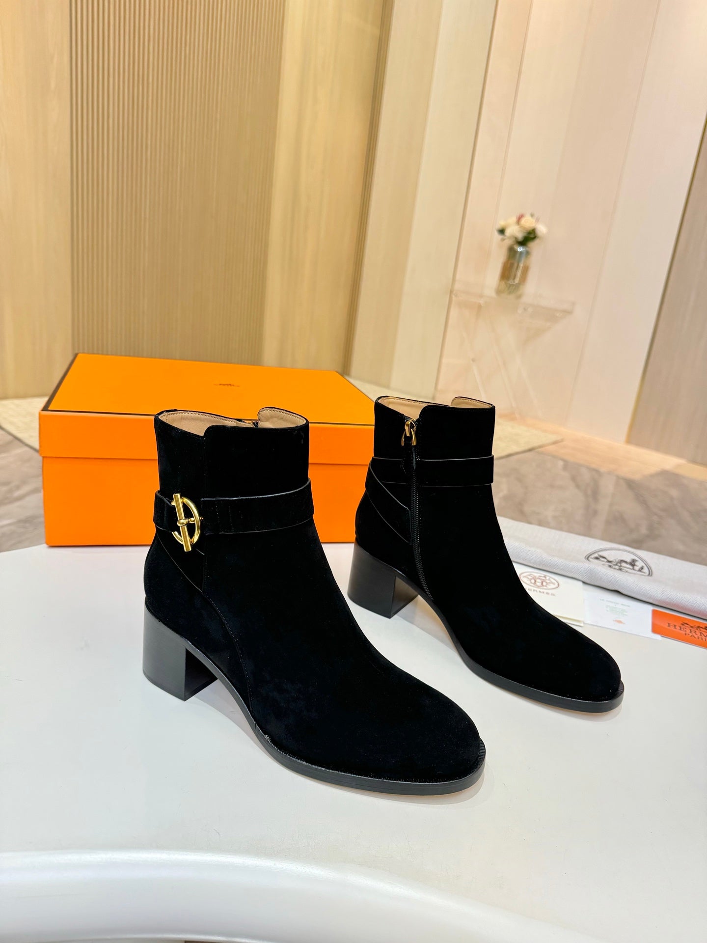 Black suede ankle boots with gold logo buckle and chunky block heel