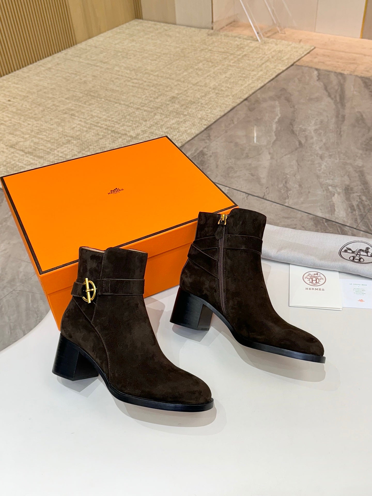Pair of Hermes black suede ankle boots with gold logo buckle and mid-height block heel