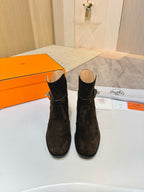 Pair of women’s black suede ankle boots with side buckle straps and block heels