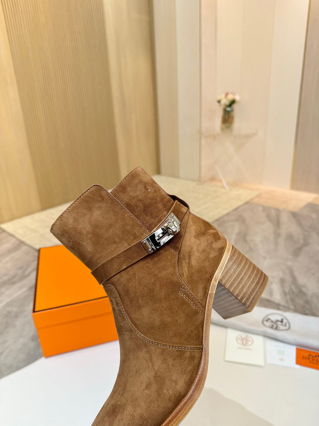 Side view of suede ankle boot with buckle strap and block heel, brown suede