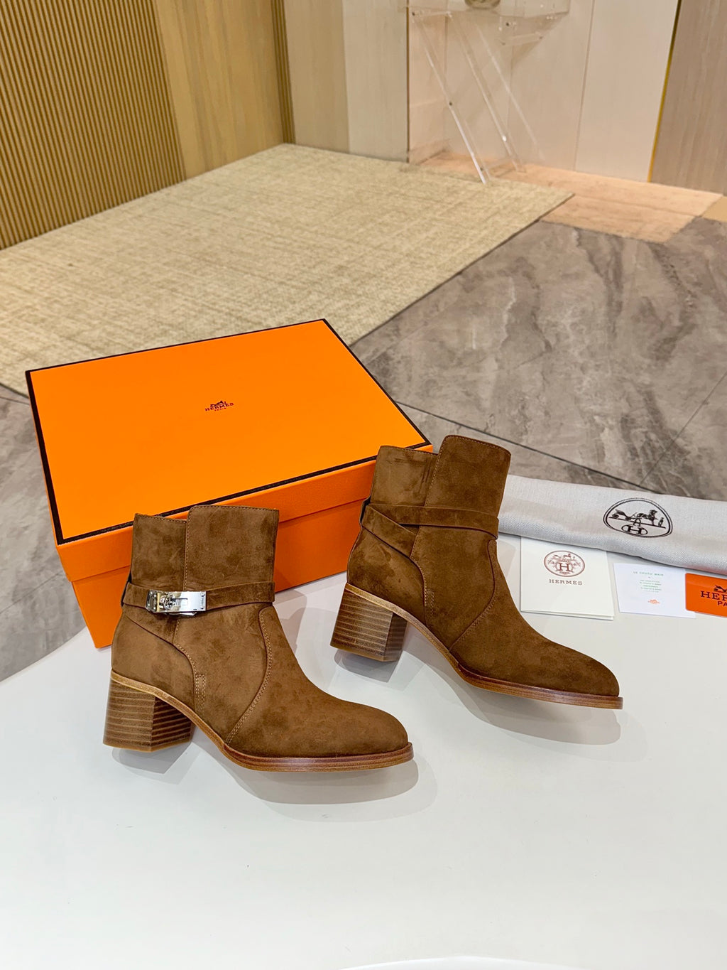 Pair of suede ankle boots with side buckle and block heel, brown suede