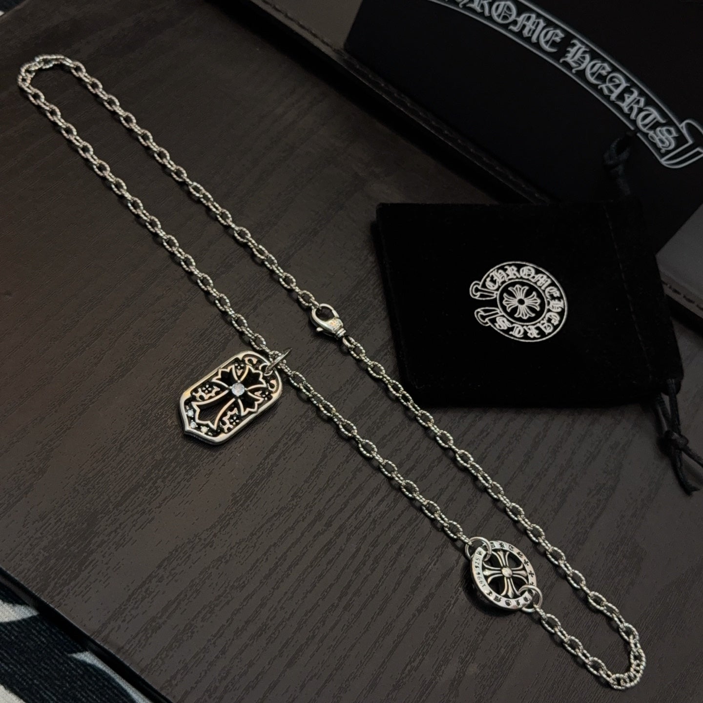 Pair of silver-tone pendant necklaces with shield and cross-shaped charms