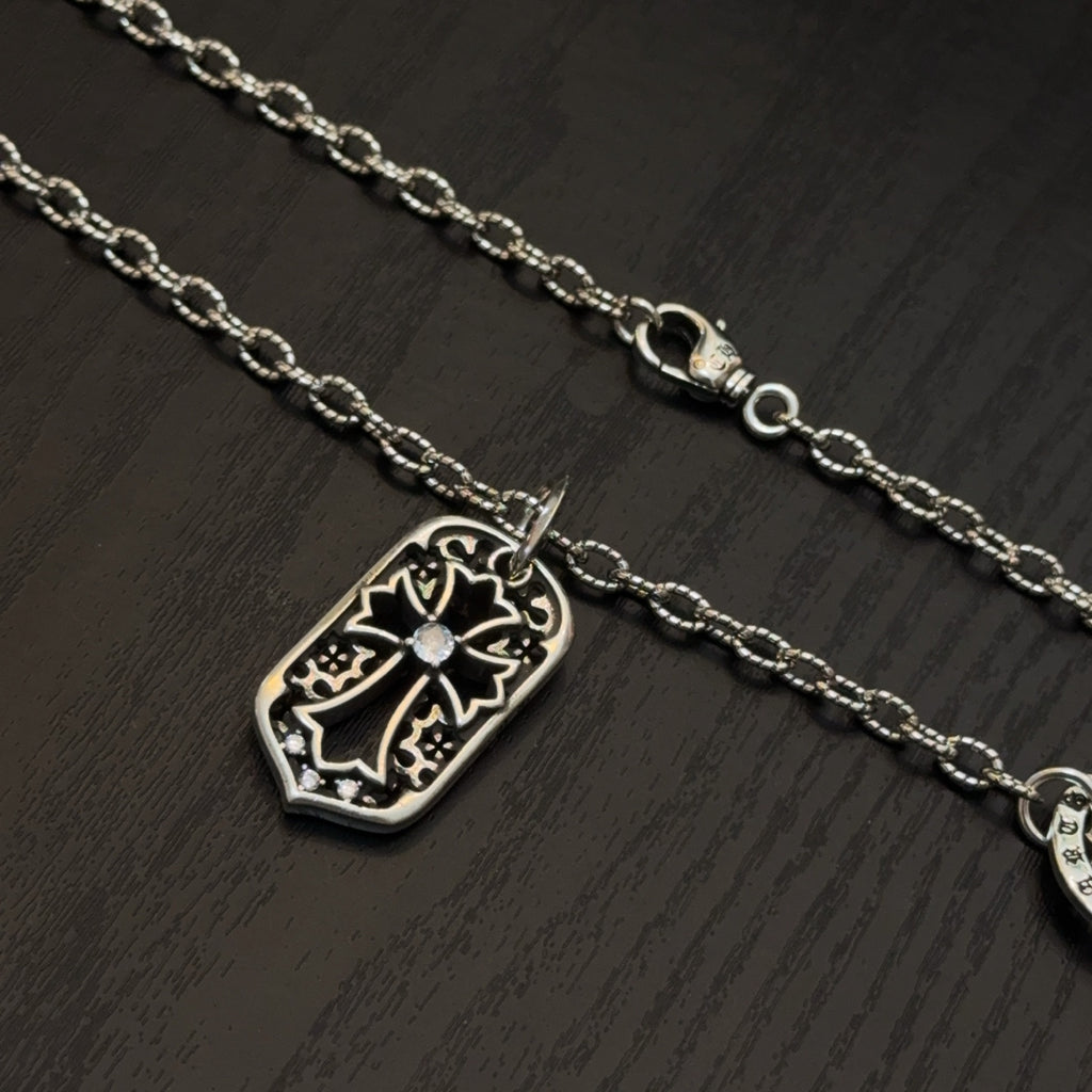Silver-tone pendant necklaces with shield charms, chain, and clasp detail