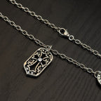 Silver-tone pendant necklaces with shield charms, chain, and clasp detail