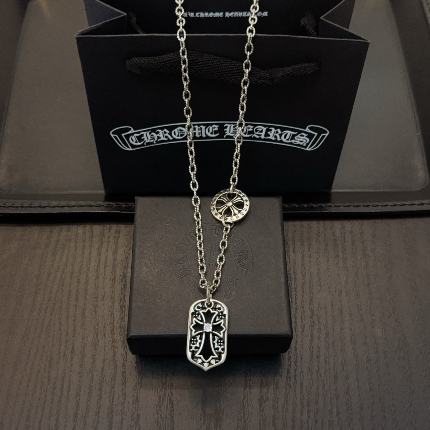 Silver-tone pendant necklace with shield-shaped charm and long chain