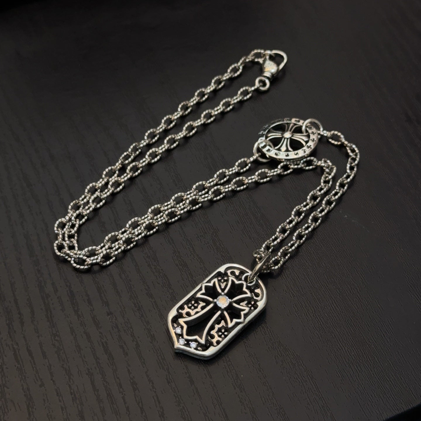 Silver-tone necklace with shield pendant and oval clasp on extended chain