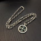 Silver-tone layered chains necklace with circular pendant and teal stone center.