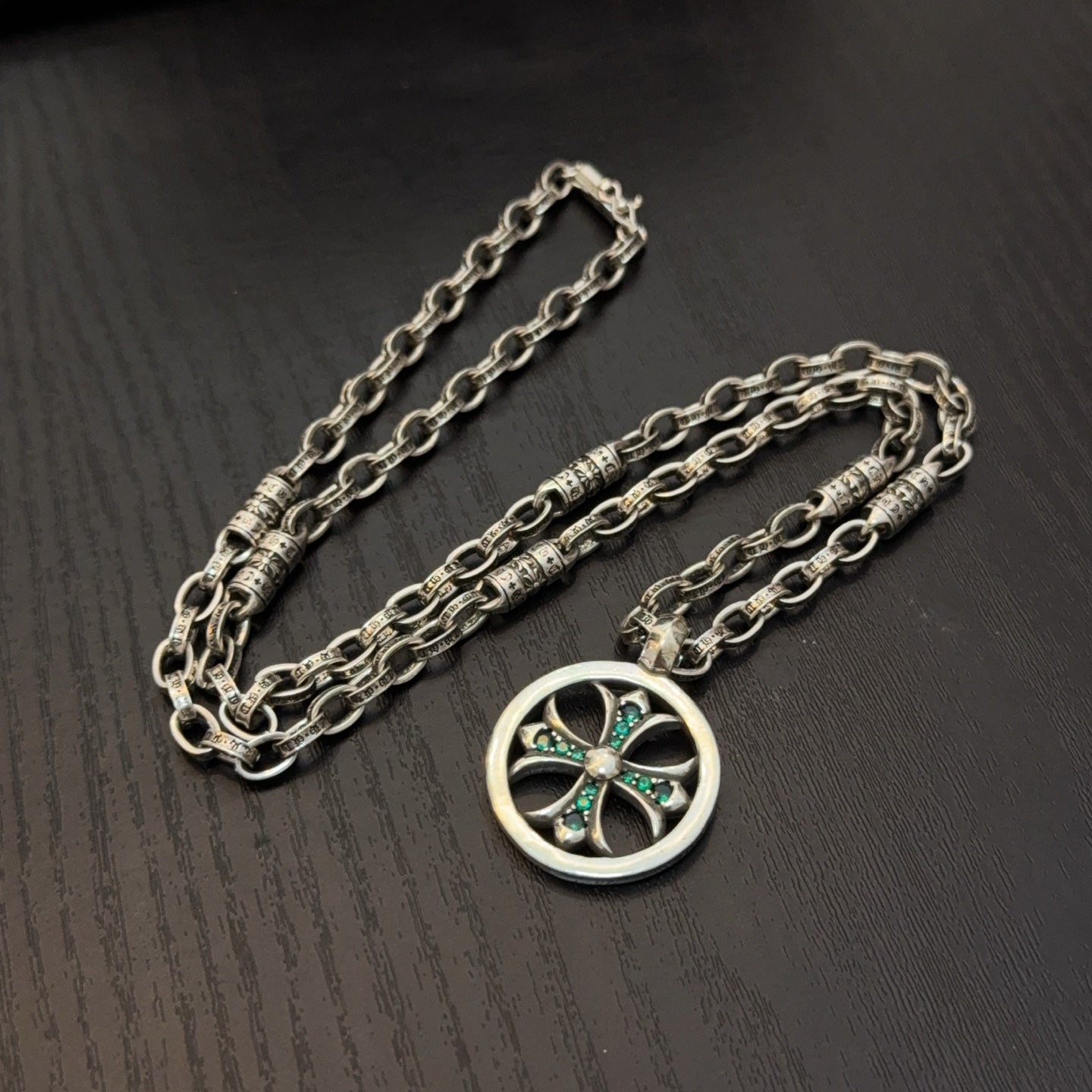 Silver-tone layered chains necklace with circular pendant and teal stone center.