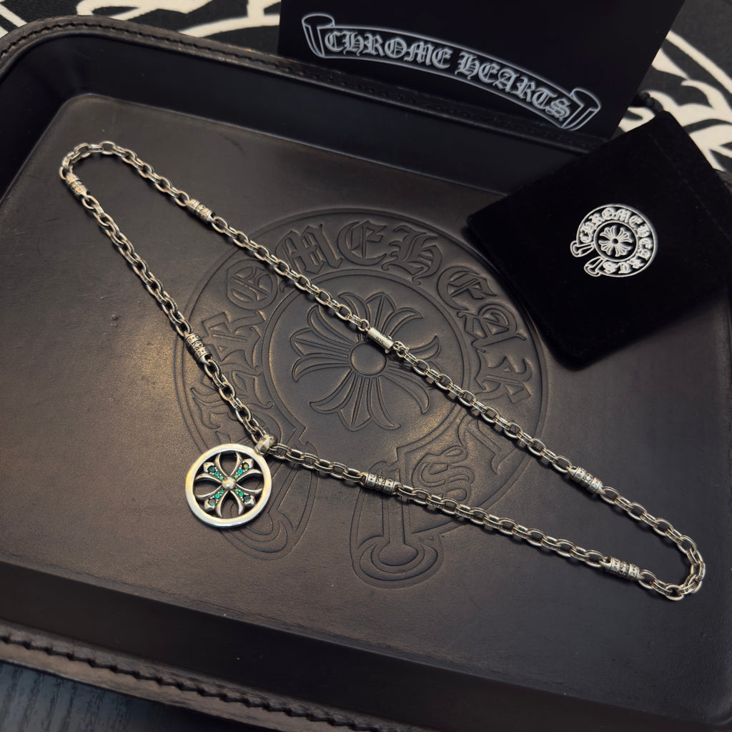 Silver-tone chain necklace with round teal-stone pendant, plus small stud earring.