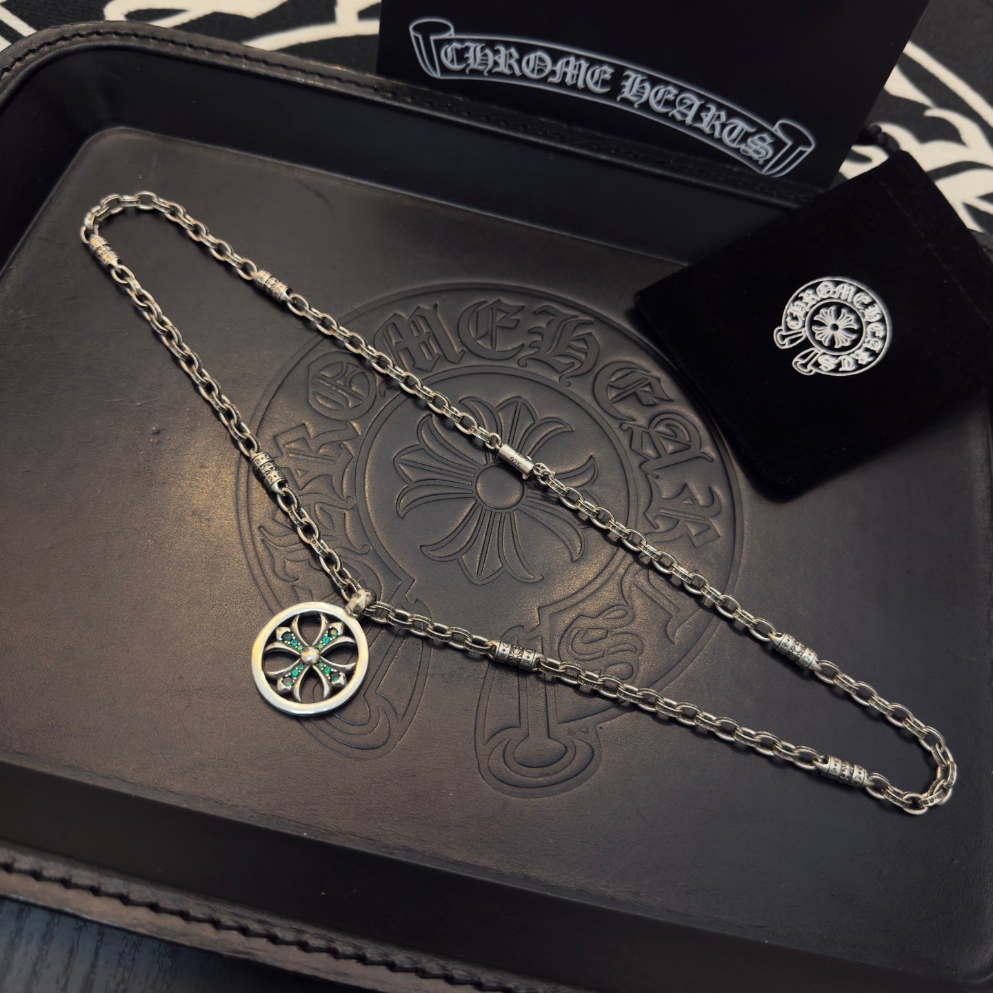 Silver-tone chain necklace with round teal-stone pendant, plus small stud earring.