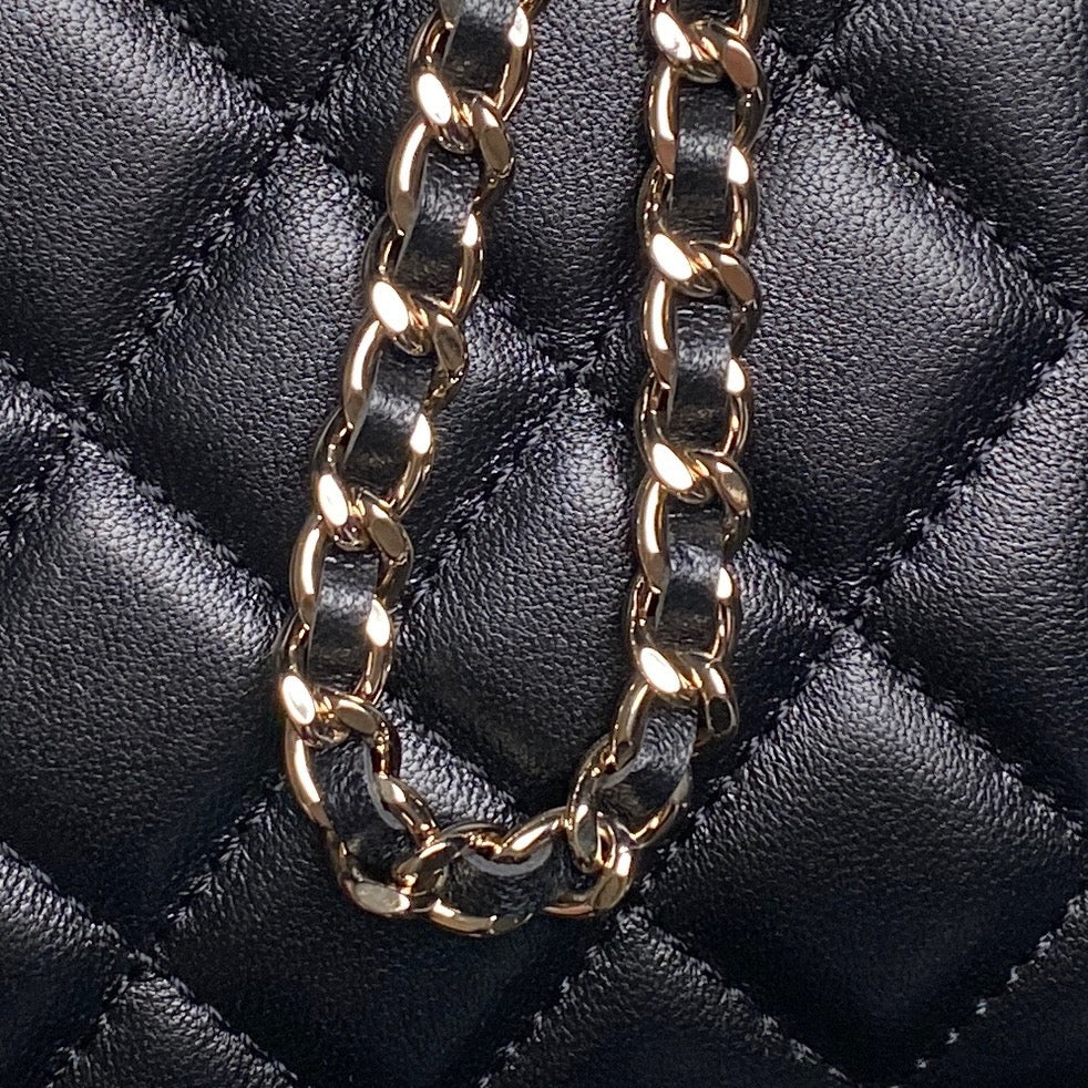 Gold-tone curb chain strap on black quilted mini bag