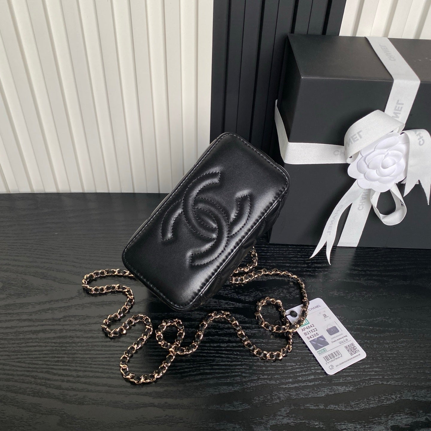 Black quilted mini crossbody bag with Chanel-style CC emboss and gold chain strap