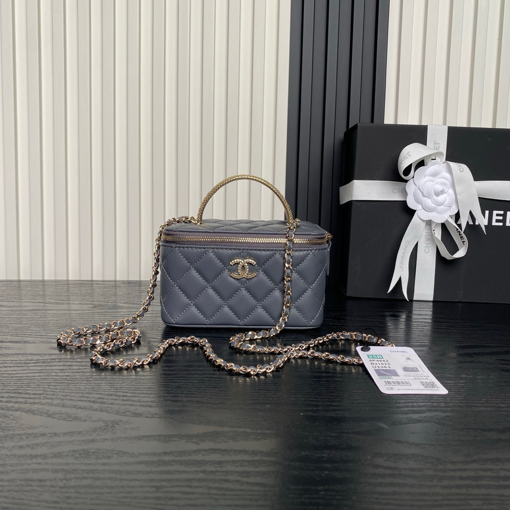 Quilted navy mini handbag with top handle, gold chain strap, and front CC logo