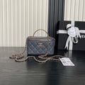 Quilted navy mini handbag with top handle, gold chain strap, and front CC logo