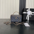 Quilted navy mini handbag with top handle, gold chain strap, and front CC logo