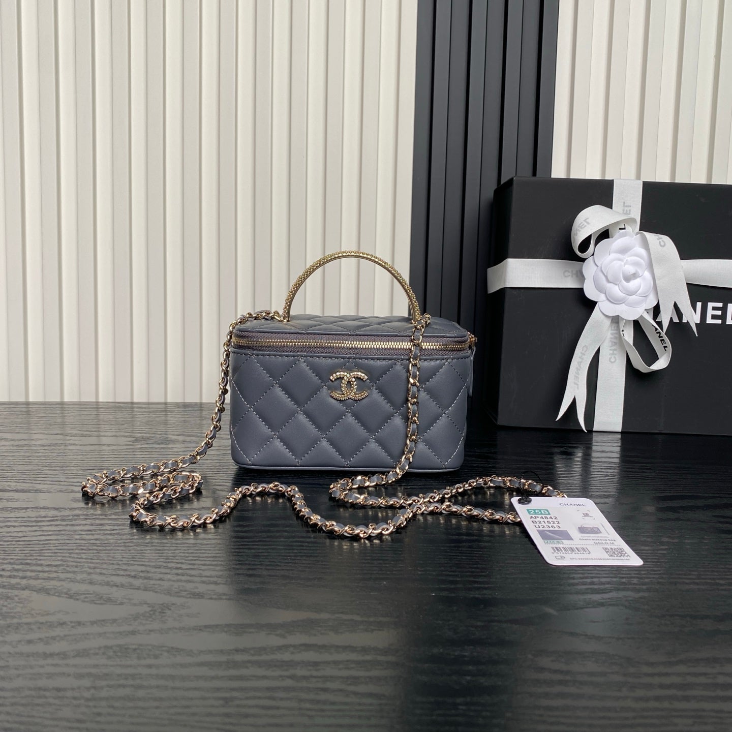 Quilted navy mini handbag with top handle, gold chain strap, and front CC logo