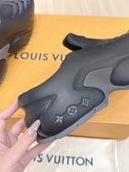 Louis Vuitton black clog sandal side profile with emblem decorations and cutouts
