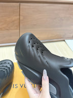 Louis Vuitton black clog sandal with curved side cutouts and perforation holes