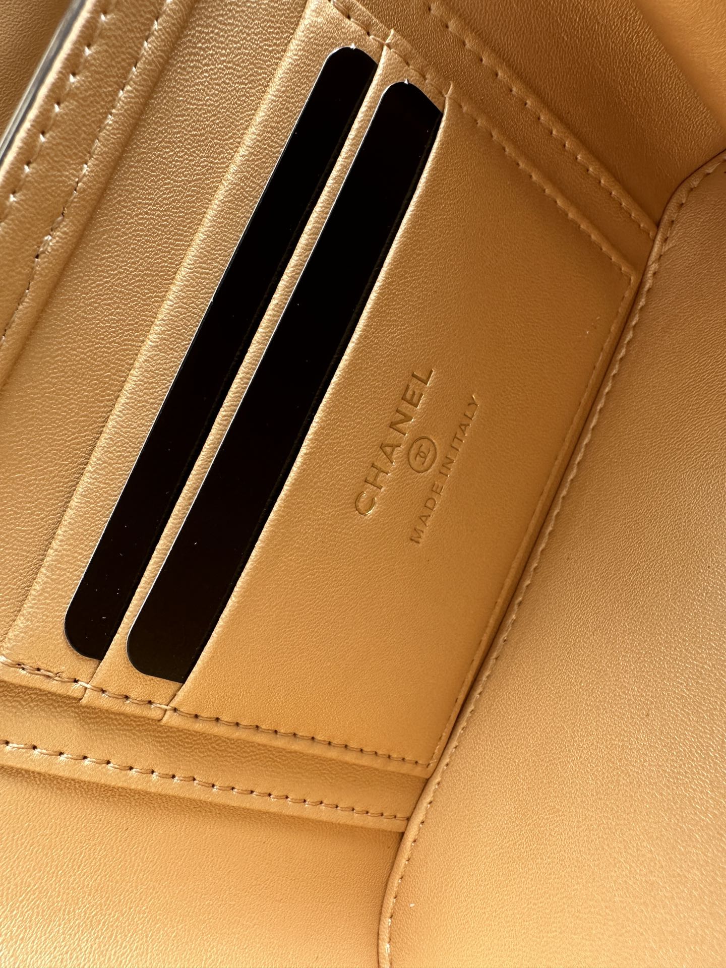 Chanel wallet card slot close-up with CHANEL embossed on tan interior lining
