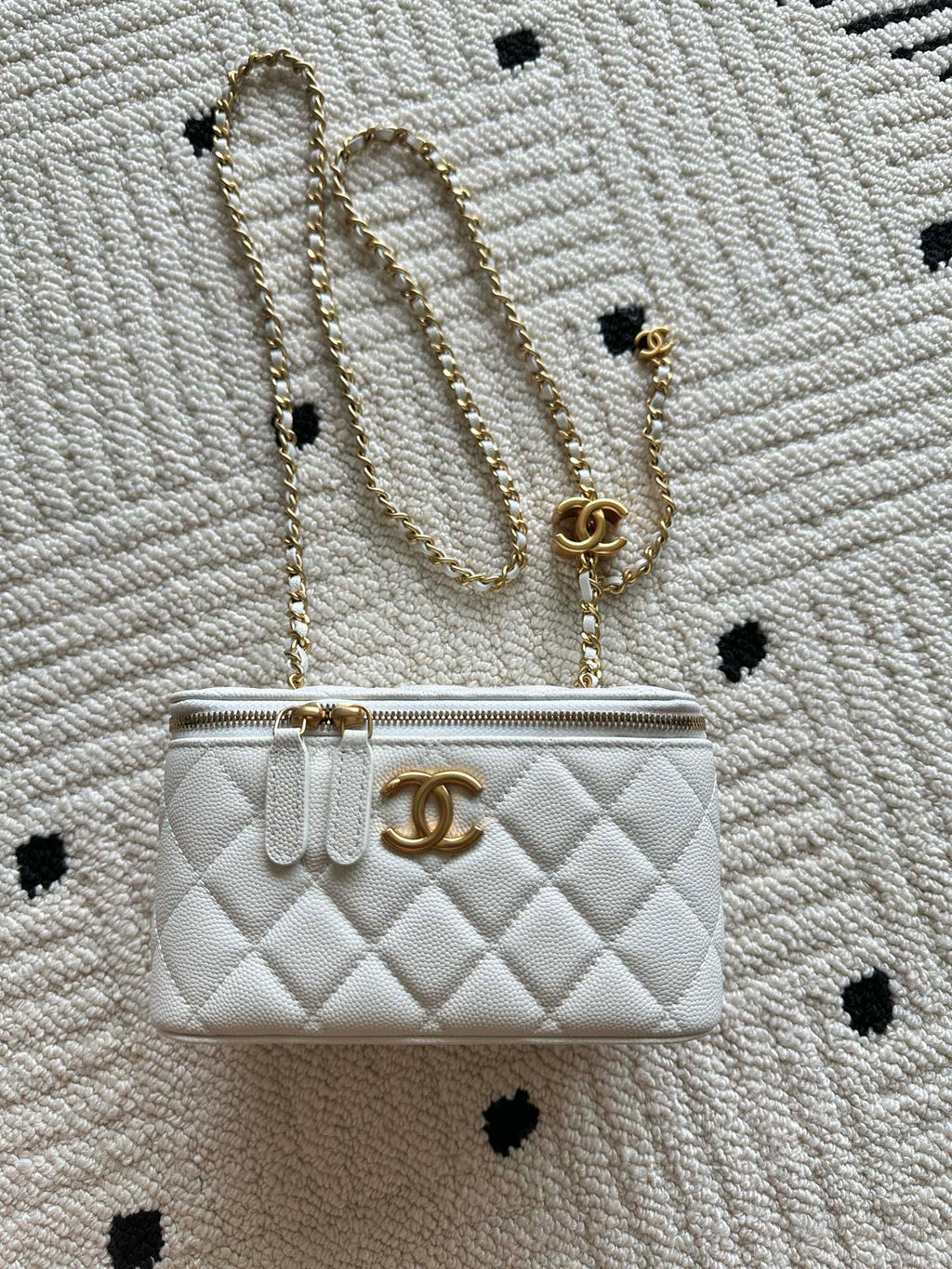 Chanel quilted mini bag with gold chain strap and turn-lock closure, white