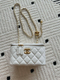 Chanel quilted mini bag with gold chain strap and turn-lock closure, white