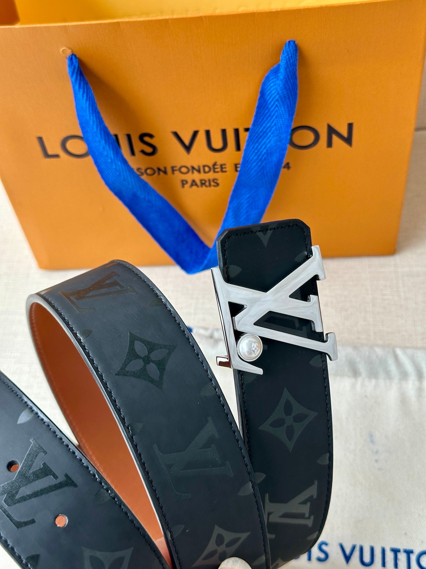 Louis Vuitton belt with dark monogram strap and silver-toned LV buckle detail