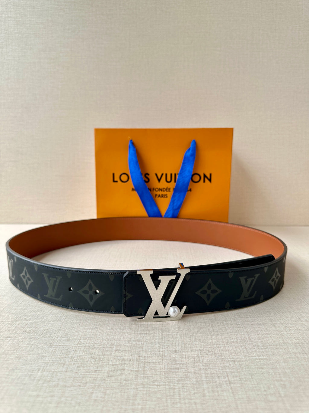 Louis Vuitton monogram belt with dark strap and polished metal LV buckle