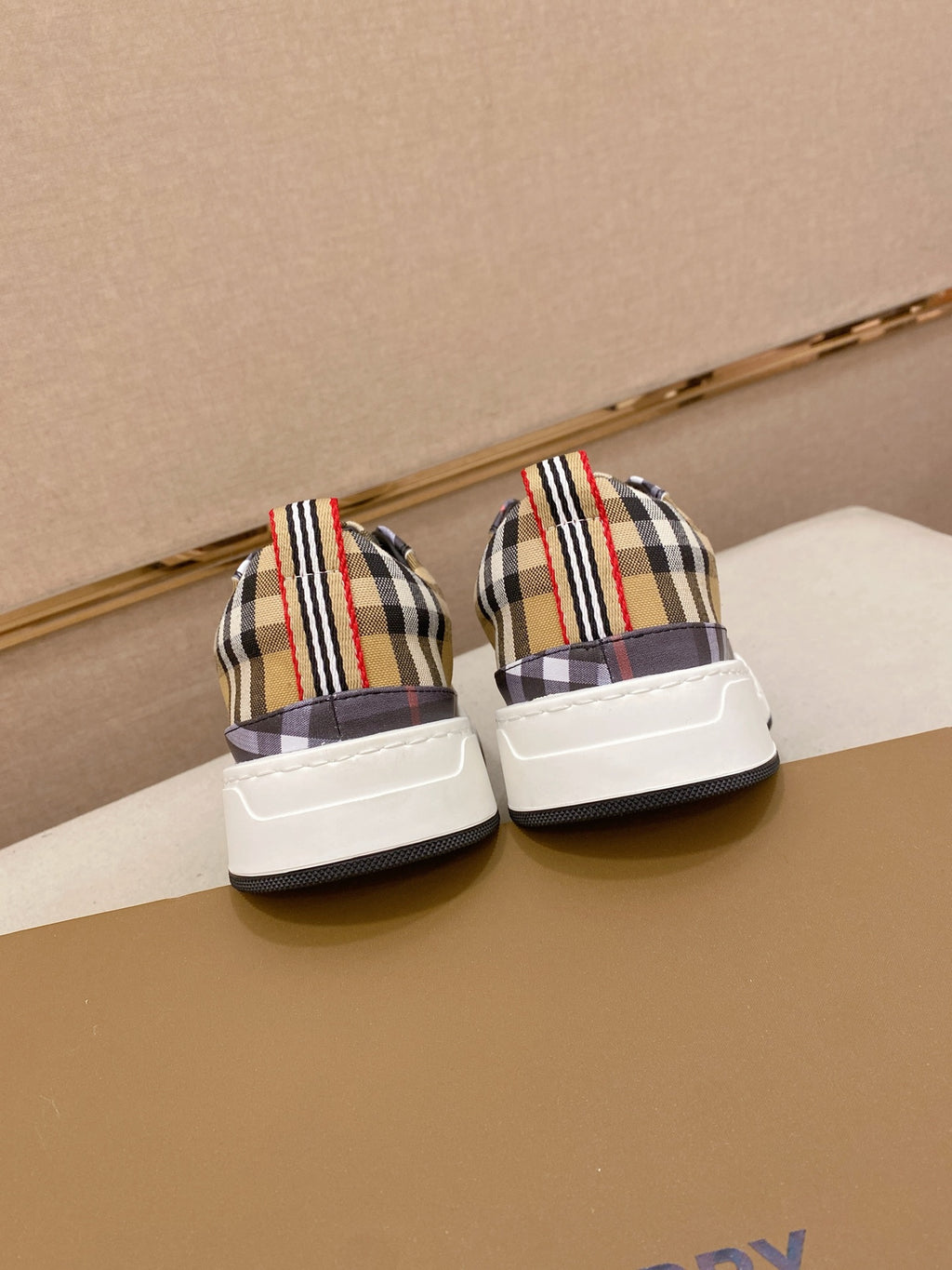 Pair of plaid low-top sneakers with white heel panels and striped collars