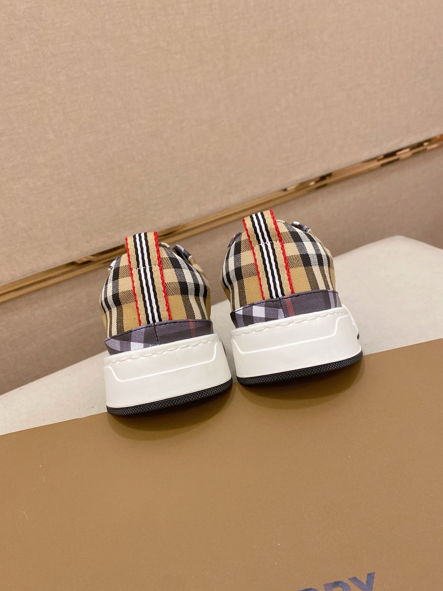 Pair of plaid low-top sneakers with white heel panels and striped collars