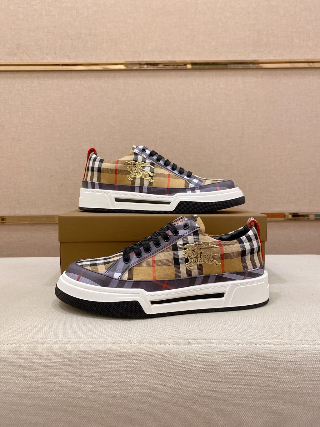 Pair of plaid low-top sneakers with black laces, white soles, red B logo accents