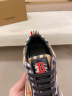 Sneaker tongue close-up with black lining and red B logo patch, plaid fabric