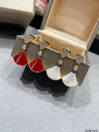 Gold-tone dangling earrings with red and white drop charms and crystal accents