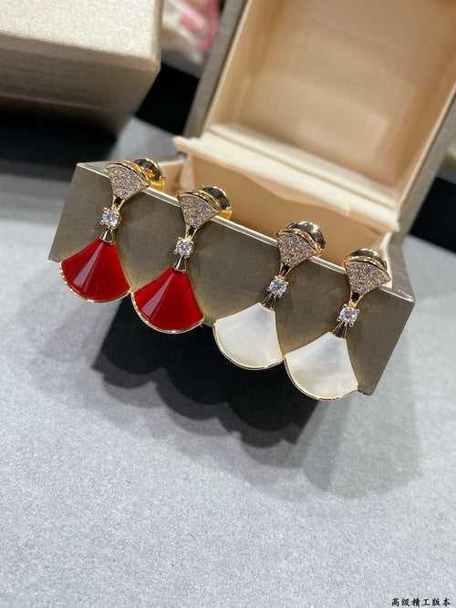 Gold-tone dangling earrings with red and white drop charms and crystal accents