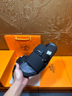 Handheld black slide sandals with H buckle and textured straps