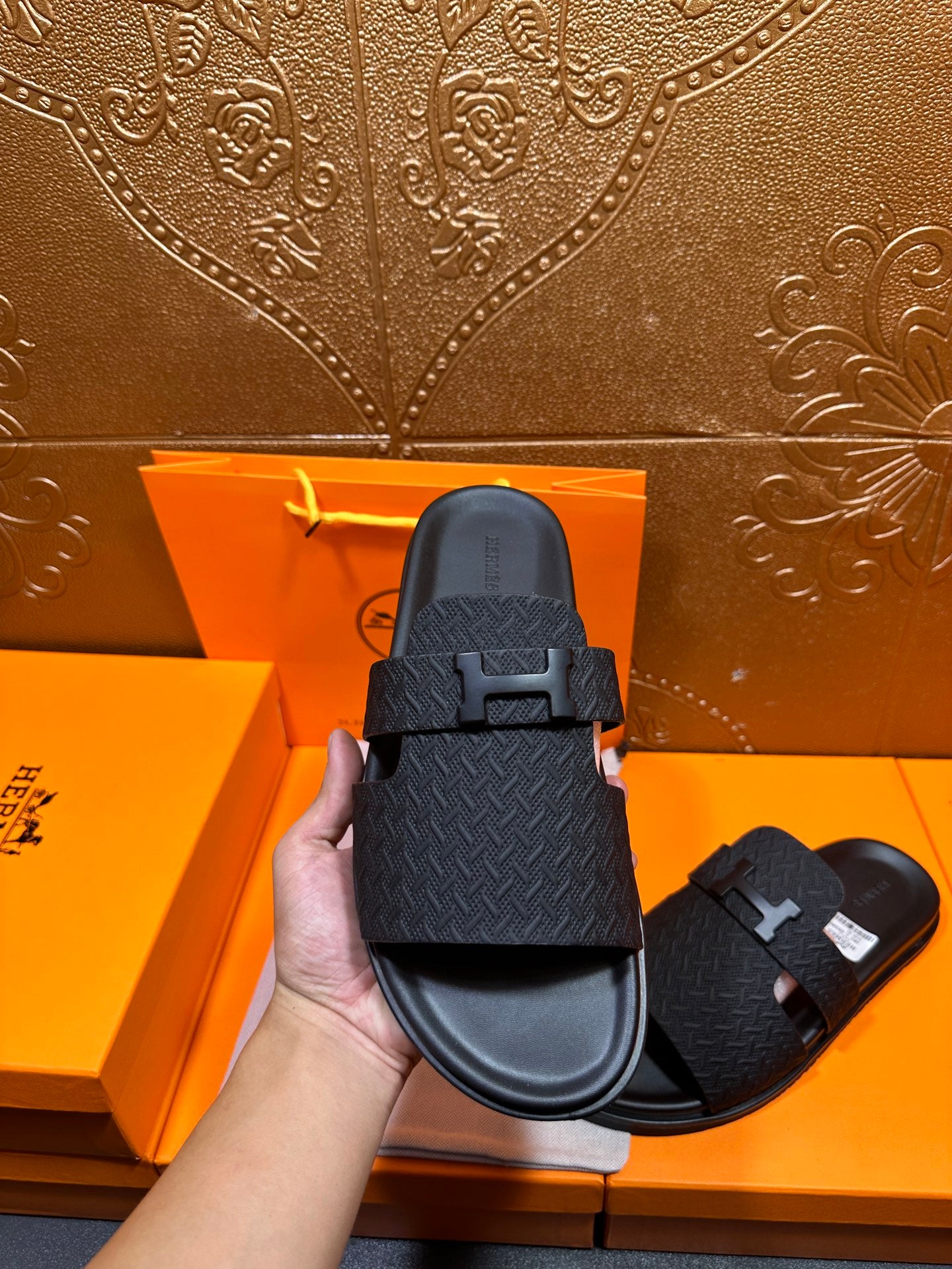 Black slide sandal featuring H buckle on textured upper