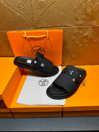 Black textured slide sandals with H buckle on footbed straps