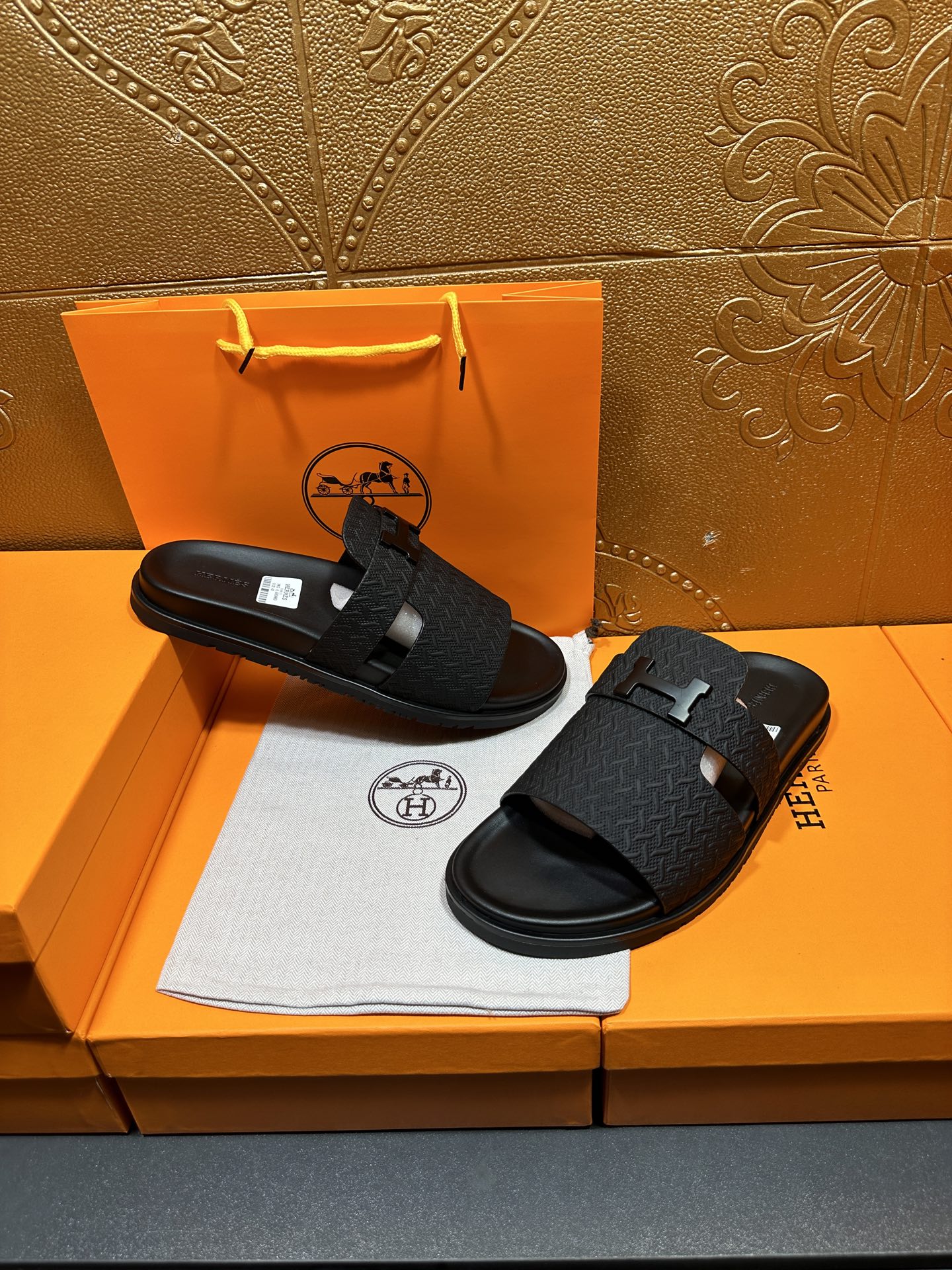 Black textured slide sandals with H buckle on footbed straps