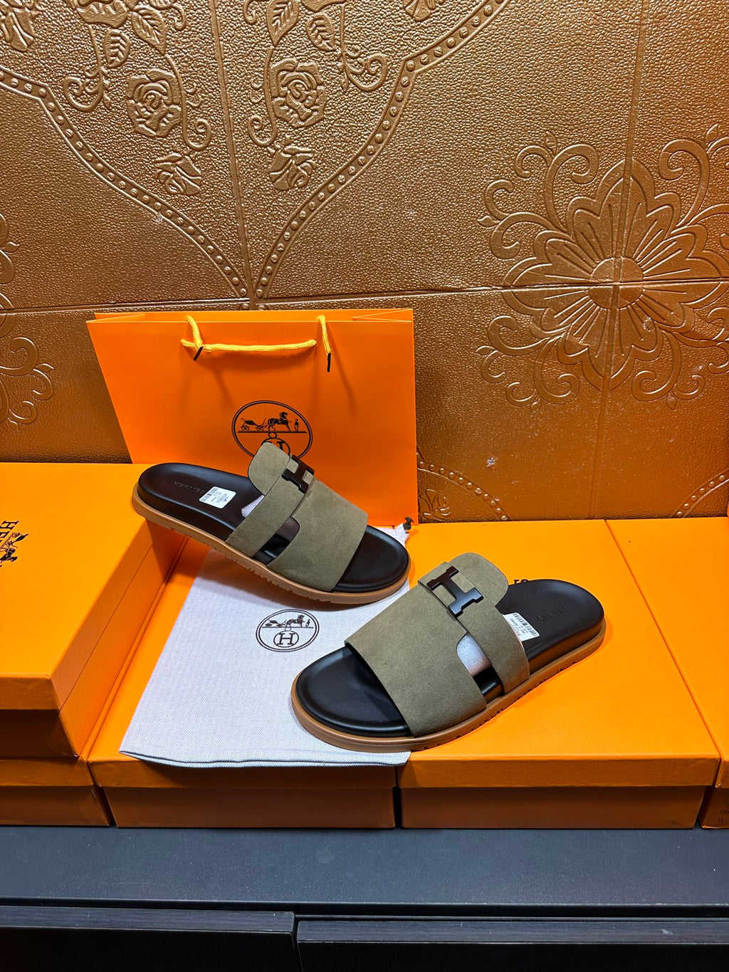 Olive suede slide sandals with H buckle straps and black footbed