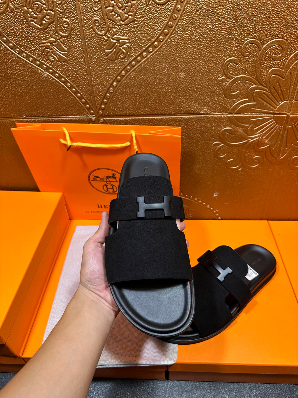 Hermes black slide sandal close-up of H buckle strap