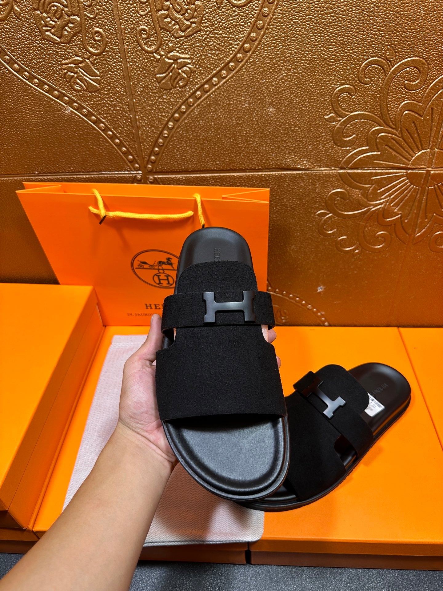 Hermes black slide sandal close-up of H buckle strap